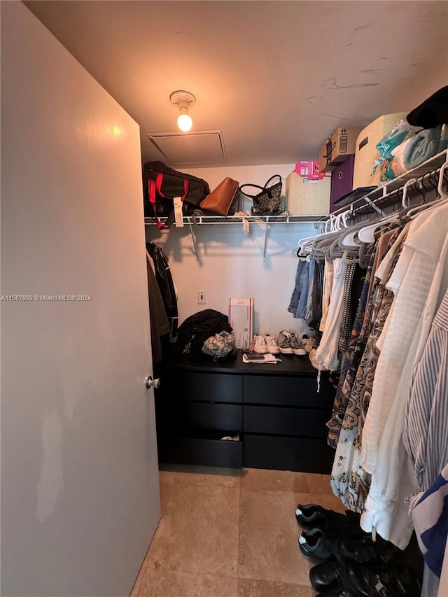 walk in closet featuring light tile floors