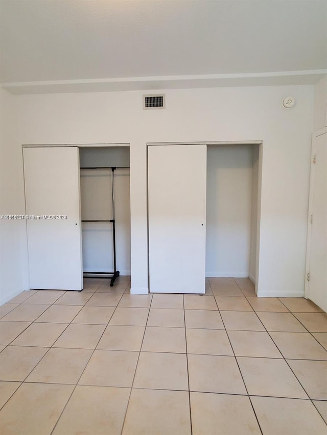 unfurnished bedroom featuring light tile flooring