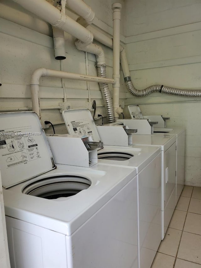 laundry area featuring electric dryer hookup, washing machine and dryer, and light tile floors