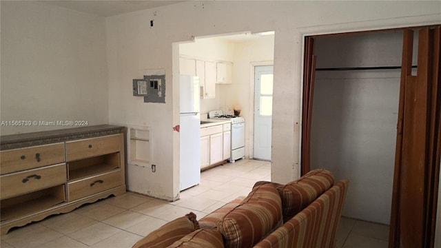 kitchen with white cabinetry, white appliances, and light tile patterned floors