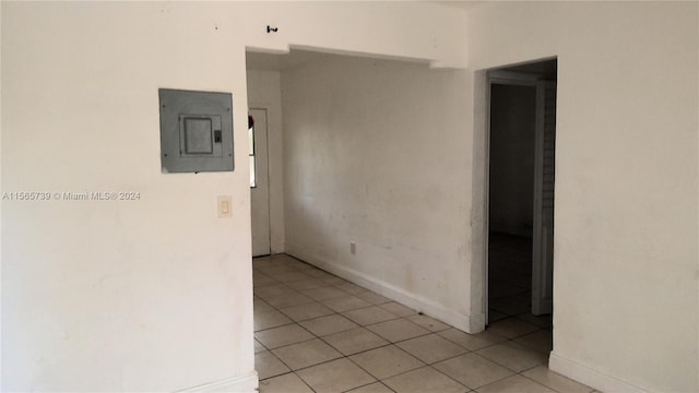 hall featuring light tile patterned floors and electric panel