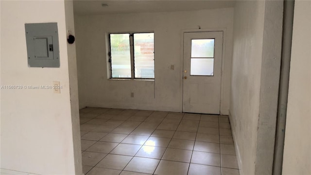 empty room with light tile patterned floors and electric panel