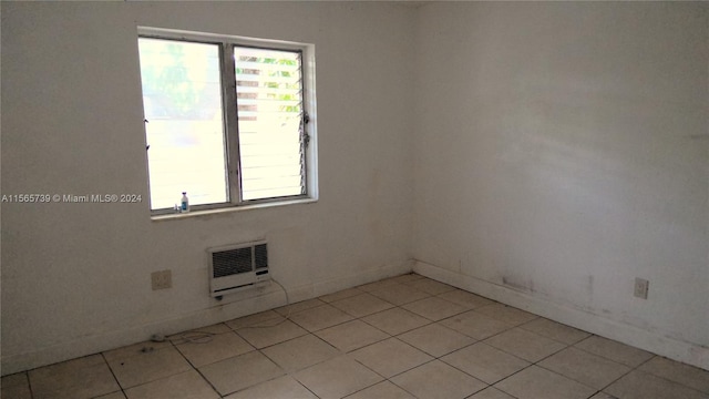 tiled empty room featuring an AC wall unit