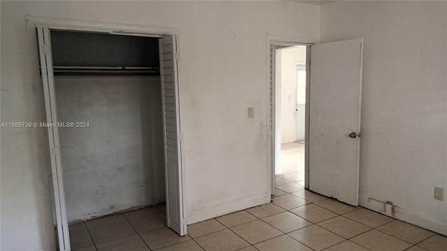 unfurnished bedroom with light tile patterned floors and a closet