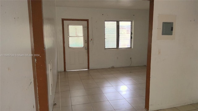 interior space with light tile patterned floors and electric panel