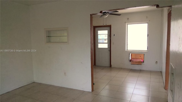 unfurnished room with light tile patterned flooring and ceiling fan