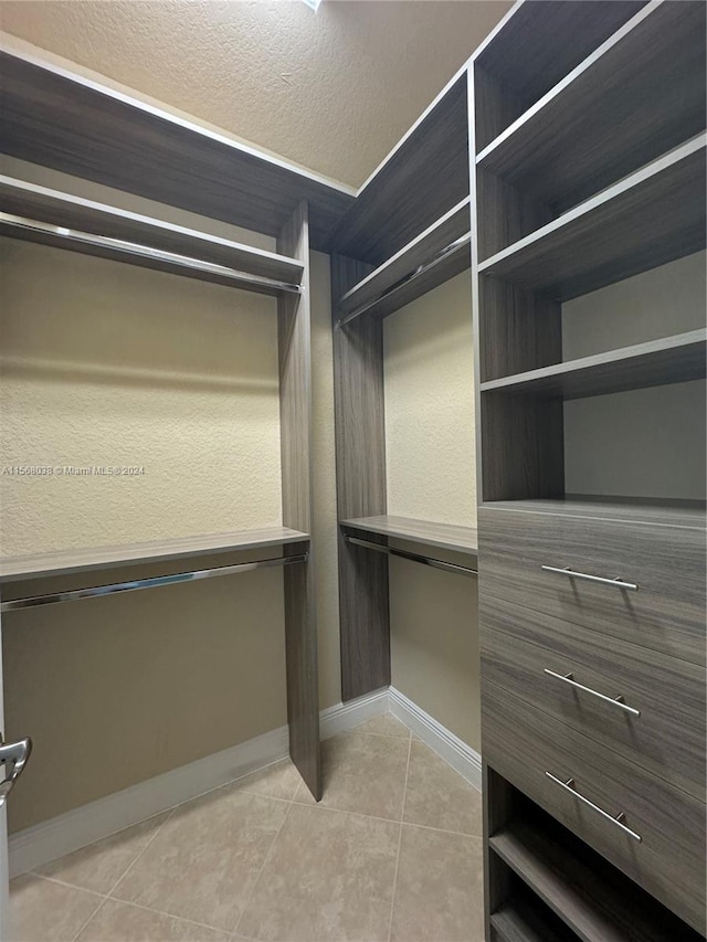 walk in closet featuring light tile patterned flooring