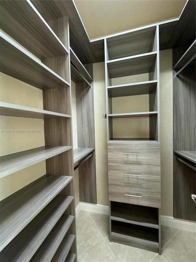 walk in closet with light tile patterned floors