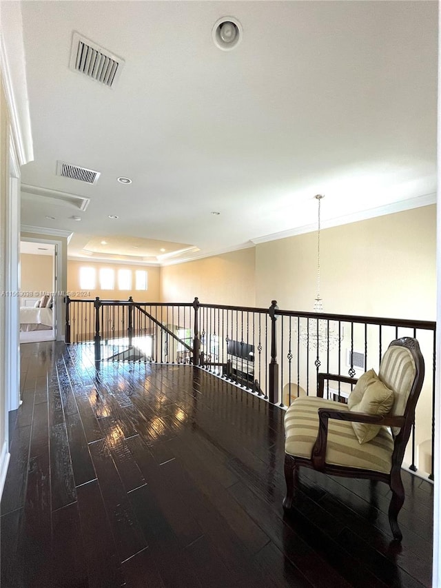 corridor with dark wood-type flooring, a notable chandelier, and ornamental molding