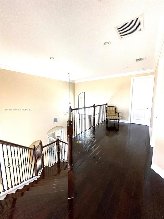 hall featuring crown molding, an inviting chandelier, and dark hardwood / wood-style floors