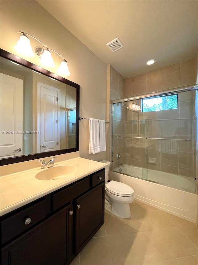 full bathroom featuring toilet, vanity, shower / bath combination with glass door, and tile patterned flooring