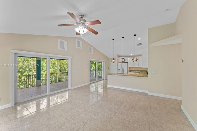 unfurnished living room featuring ceiling fan, light tile patterned floors, and high vaulted ceiling