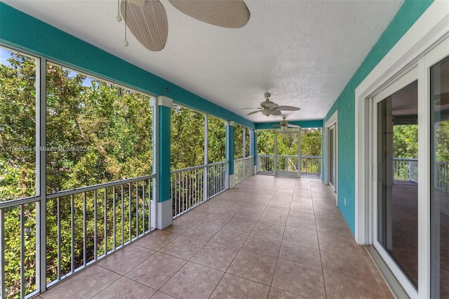 unfurnished sunroom with ceiling fan