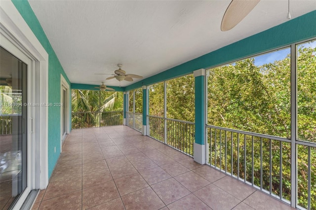 unfurnished sunroom featuring a wealth of natural light and ceiling fan