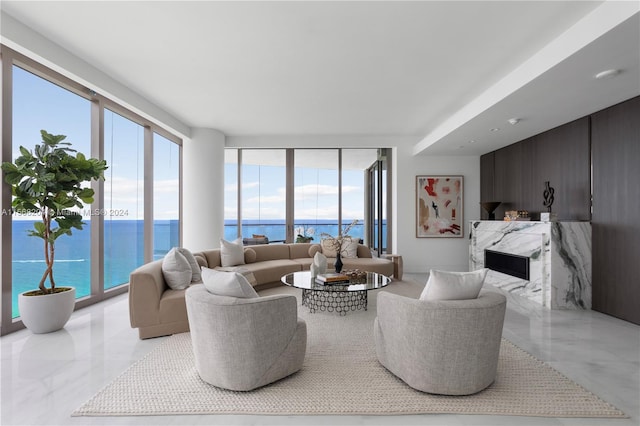 living room featuring a fireplace, a water view, and a healthy amount of sunlight