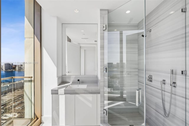 full bath with a stall shower, vanity, and recessed lighting