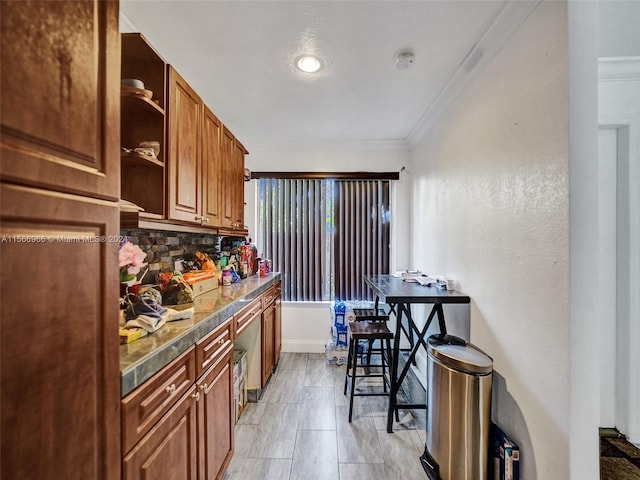 kitchen featuring tasteful backsplash, crown molding, and light tile floors