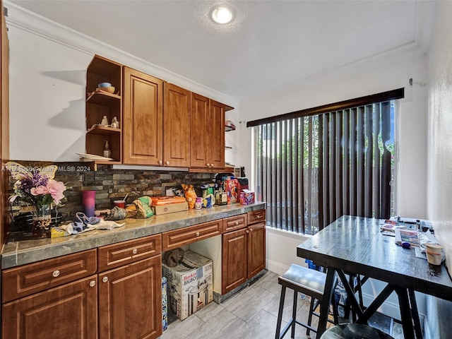 kitchen with backsplash, crown molding, and light tile flooring