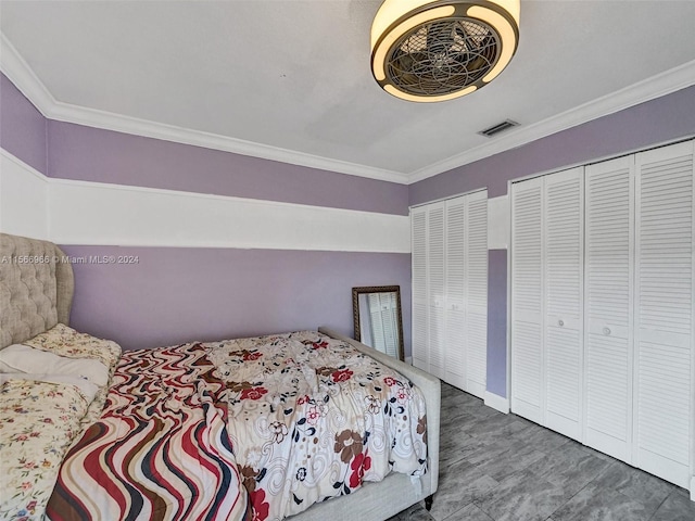 bedroom with multiple closets and ornamental molding