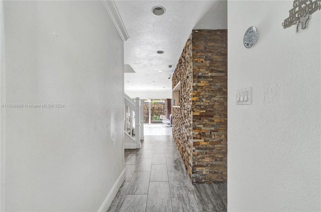 hallway featuring light tile floors and a textured ceiling