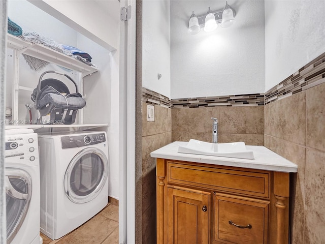 bathroom featuring tile walls, backsplash, vanity, washer and clothes dryer, and tile floors