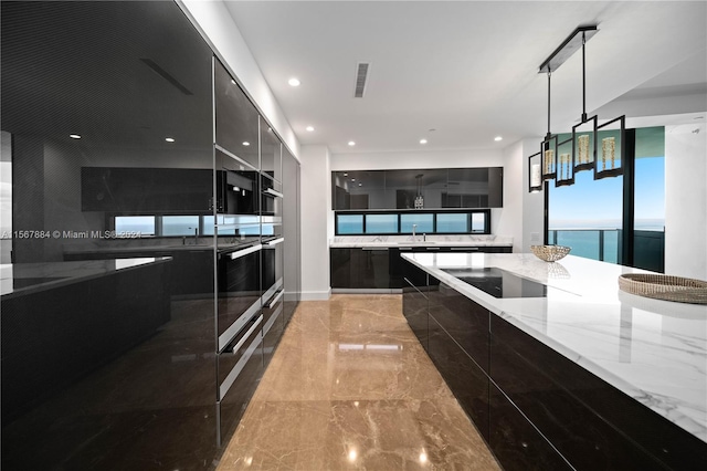 kitchen featuring a water view, black appliances, light stone counters, pendant lighting, and light tile floors