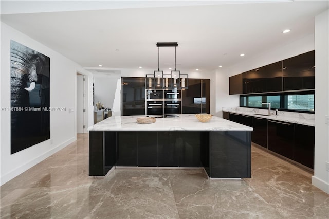 kitchen featuring light stone counters, light tile floors, a kitchen island, sink, and decorative light fixtures