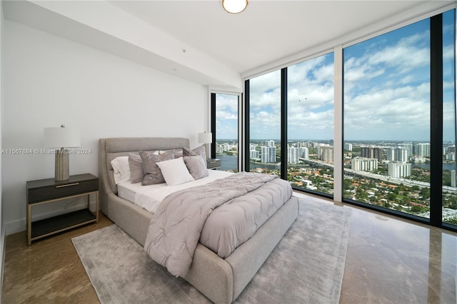 bedroom with a wall of windows, concrete floors, and access to outside