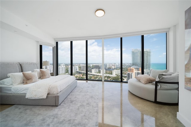 bedroom featuring a water view, a wall of windows, access to exterior, and multiple windows