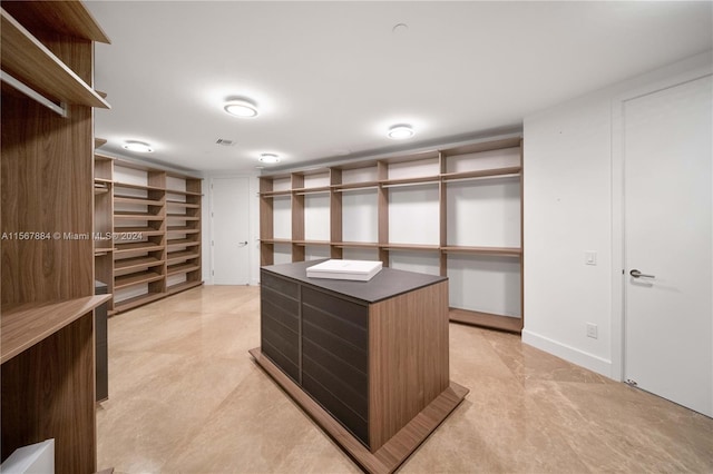 walk in closet with light tile flooring