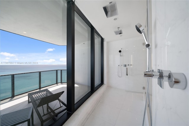 interior space with walk in shower, tile flooring, and a water view