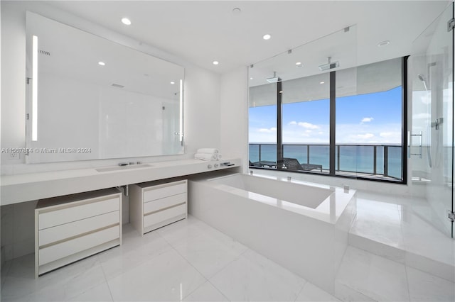 bathroom with a water view, large vanity, separate shower and tub, and tile flooring