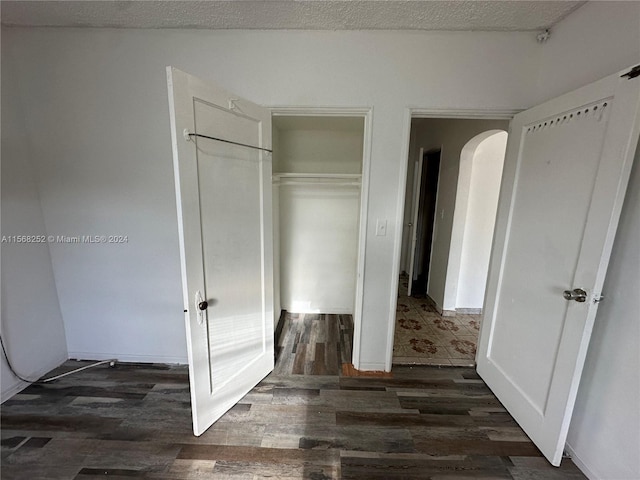 interior space with a closet, dark hardwood / wood-style floors, and a textured ceiling