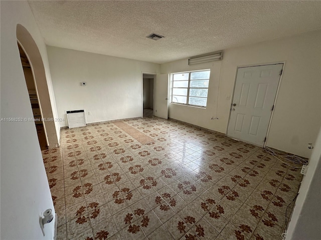 unfurnished room featuring light tile floors and a textured ceiling