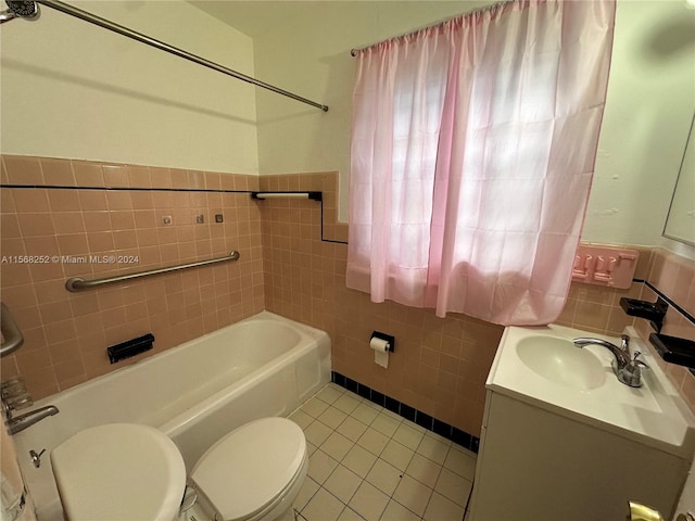 full bathroom with tile flooring, tiled shower / bath, tile walls, toilet, and vanity