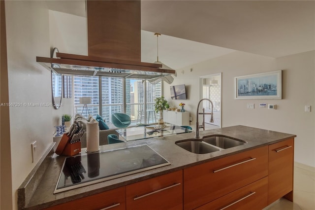 kitchen featuring sink, dark stone countertops, black electric cooktop, and custom range hood