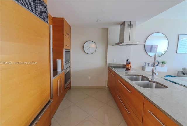 kitchen with stainless steel appliances, sink, light stone counters, island exhaust hood, and light tile patterned flooring