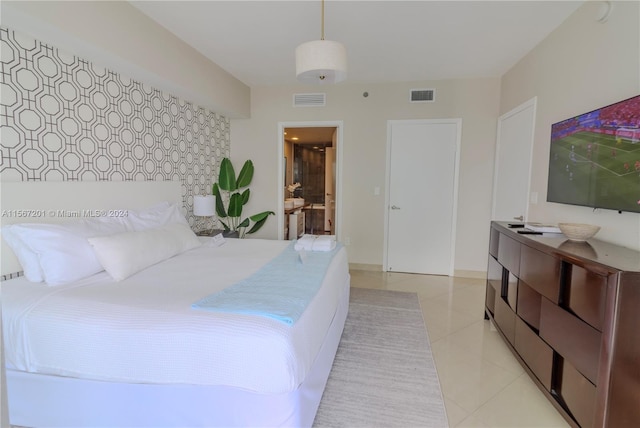 bedroom with light tile patterned flooring and connected bathroom