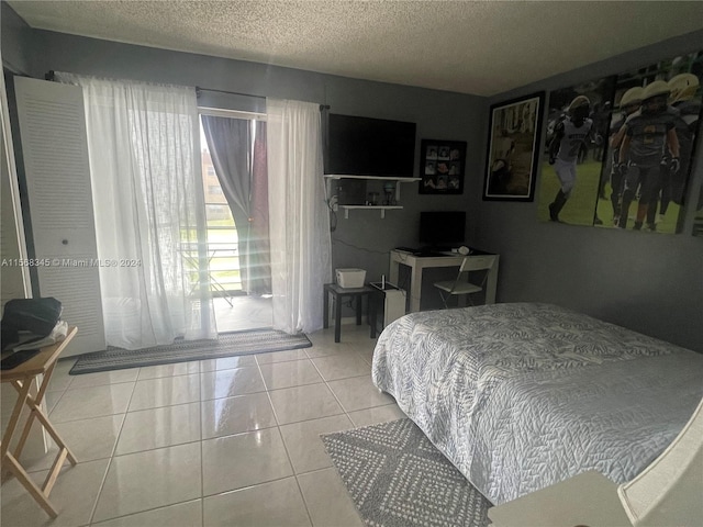 bedroom featuring light tile flooring and a textured ceiling