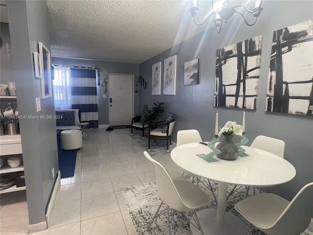 dining space with an inviting chandelier, a textured ceiling, and light tile flooring