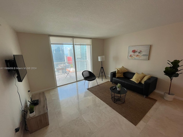 tiled living room featuring floor to ceiling windows and a textured ceiling