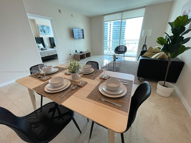 dining area featuring a wall of windows and light tile floors