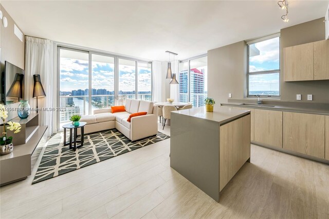 4010 S Ocean Dr Unit R3308, Hollywood, FL 33019 - kitchen featuring a center island, modern cabinets, a sink, light wood-style floors, and light brown cabinetry