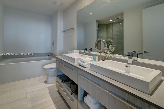 bathroom featuring toilet, tile flooring, dual vanity, and a tub