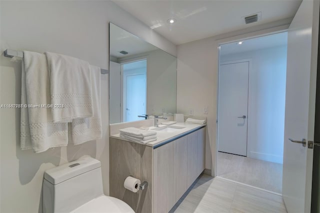 bathroom with large vanity, toilet, and tile flooring