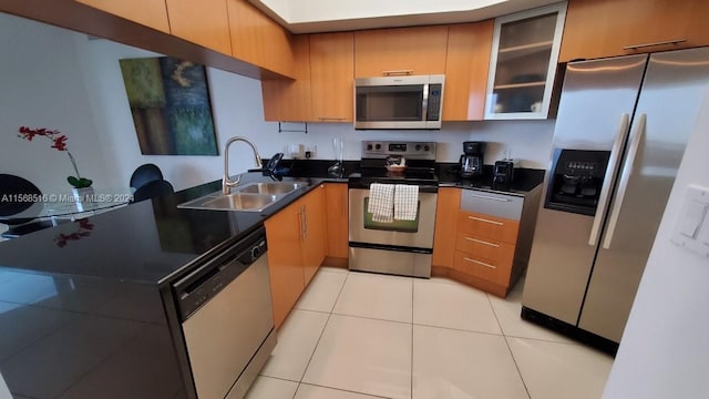 kitchen with sink, appliances with stainless steel finishes, kitchen peninsula, and light tile floors