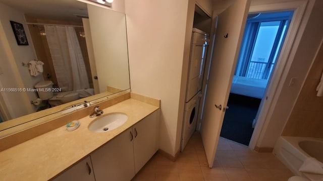 full bathroom featuring shower / bath combo with shower curtain, stacked washing maching and dryer, tile floors, toilet, and vanity