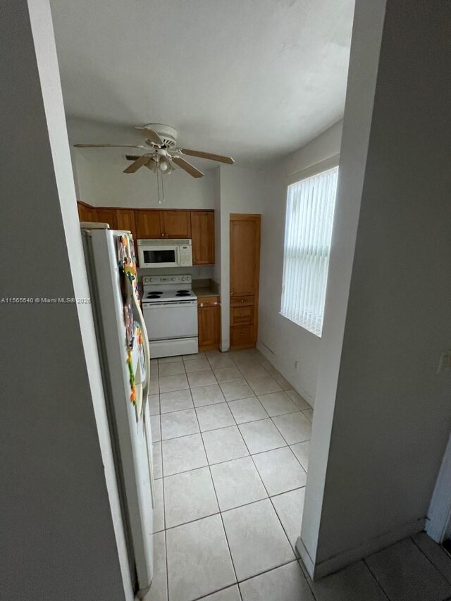 kitchen with ceiling fan, white appliances, and light tile floors