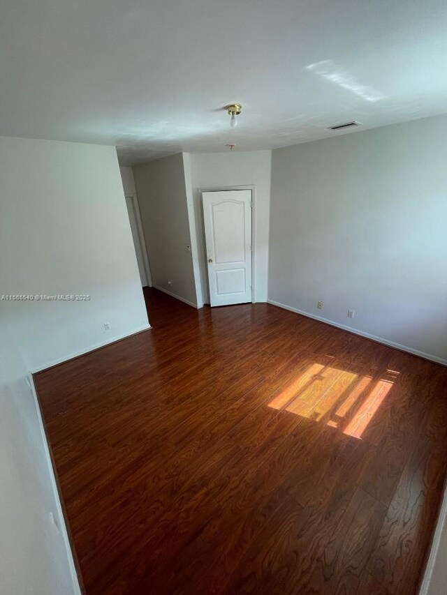 spare room with dark hardwood / wood-style floors