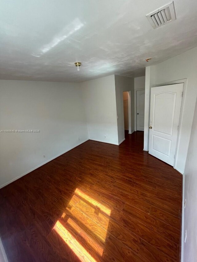 empty room with dark wood-type flooring